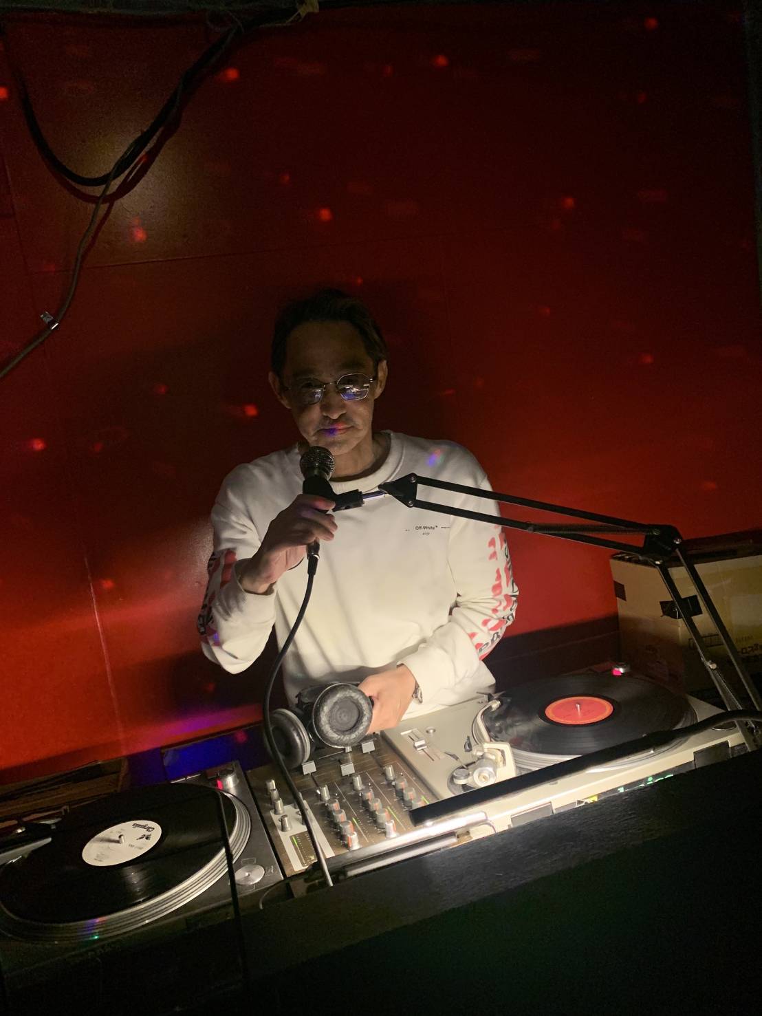 ターンテーブルの前でマイクを持つDJ